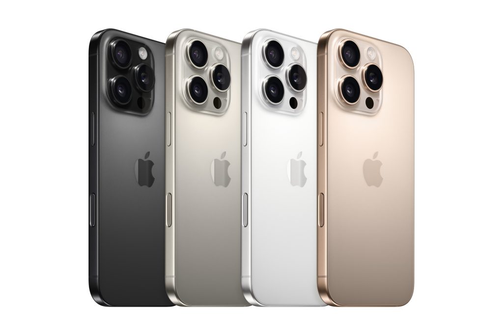 The iPhone 16 Pros fanned from left to right on a white background, the colors are (left to right) black, natural, white, and desert titanium